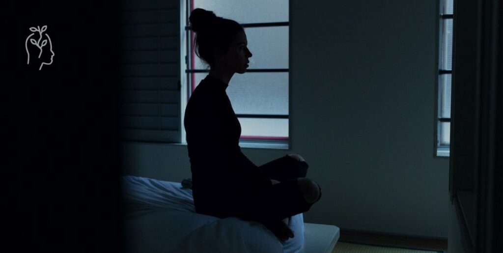 Jeune femme déprimée dans une chambre noire