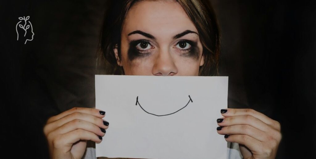 Jeune femme triste qui met un papier avec un sourire devant sa bouche