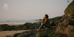 Femme assise sur la plage en train de regarder la mer
