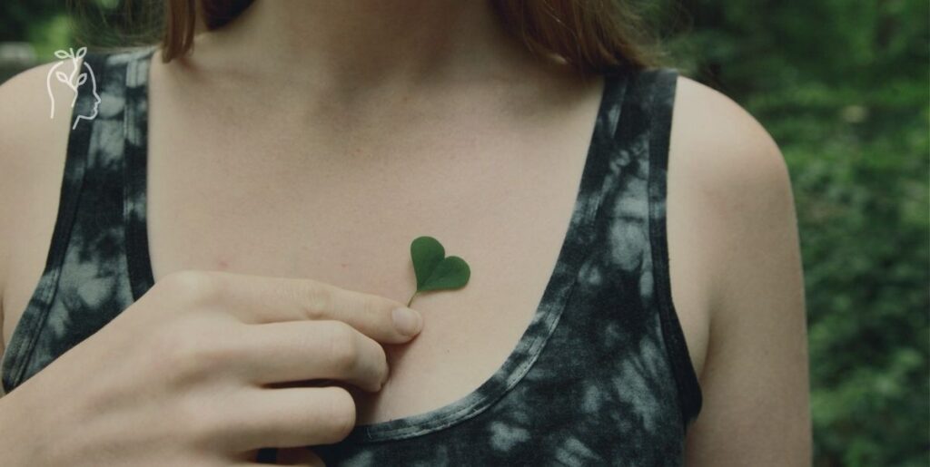 Femme mettant un coeur vert devant son coeur