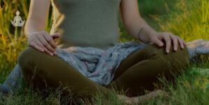 Femme assise sur l'herbe en position de méditation