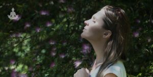 jeune femme en train de méditer dans la nature les yeux fermés