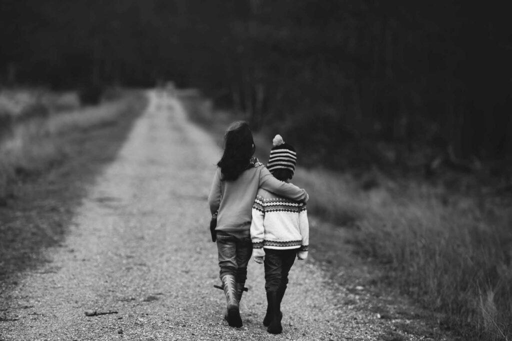 deux enfants se promenant en se tenant par les bras